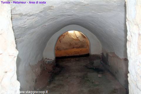 White vaulted interior at Metameur, lit archway over stone walls