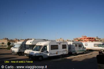 White motorhomes parked at a rest area in Tobruk, clear blue sky