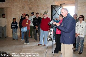 Tourists with a camera on tripod inside a stone-walled hall, Ortahisar