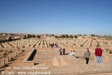Tobruk war cemetery: rows of white headstones on sand, visitors in sunlight