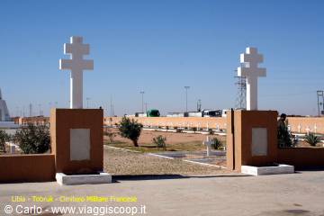 Tobruk French cemetery: two white crosses on ochre pillars under blue sky