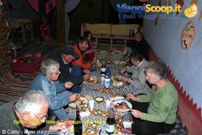 Tourists eating dinner seated on the floor of a Bedouin camp tent