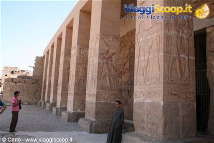 Tourist and guide beside hieroglyph-carved sandstone columns at Karnak temple