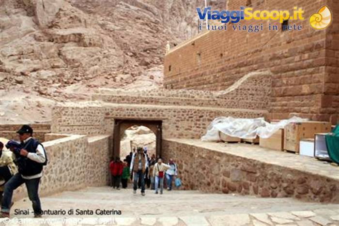 Pilgrims descend the steps toward Saint Catherine's Monastery, red stone walls
