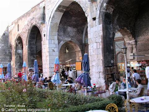 Historic stone arcades of Sivas with cafés, umbrellas and people sitting at tables
