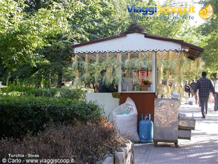 Corn kiosk in Sivas, cobs hanging from the roof, people walking by