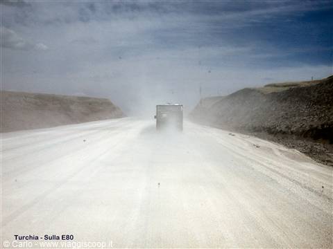 Truck raising dust on a dirt road across arid Turkish steppe