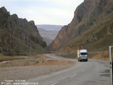 A white truck drives along the paved road between rocky gorges in Turkey