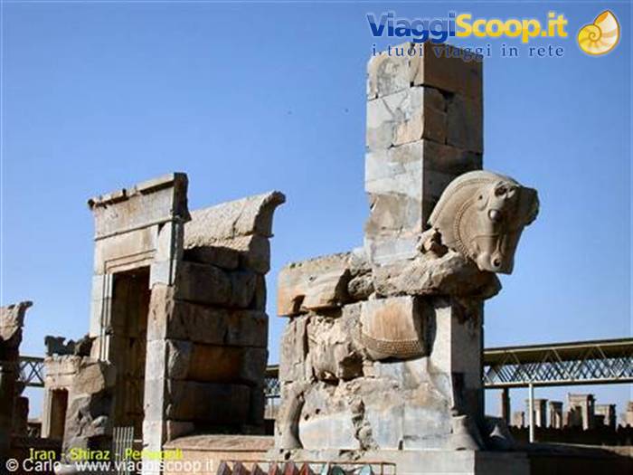 Persepolis: stone bull capital among Achaemenid ruins under blue sky