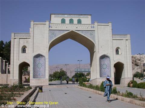 Quran Gate in Shiraz, blue tiled arch, a visitor walks beneath it