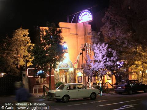 Tehran at night: white car parked outside the lit restaurant