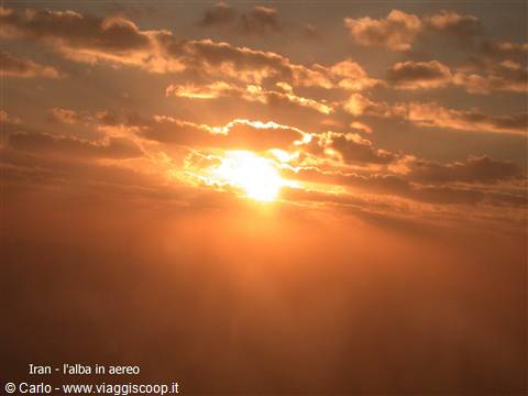 Golden sun breaking through clouds from the plane over Iran