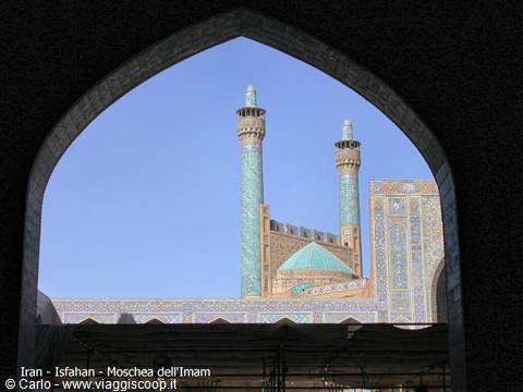 Tiled minarets of the Shah Mosque framed by an archway in Isfahan