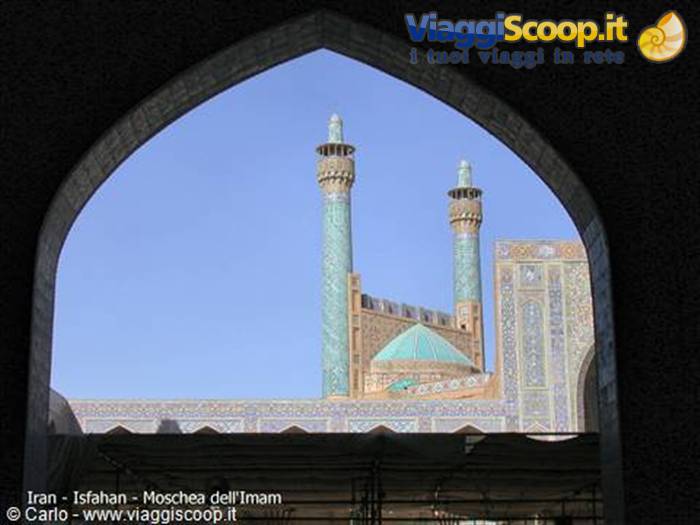 Tiled minarets of the Shah Mosque framed by an archway in Isfahan