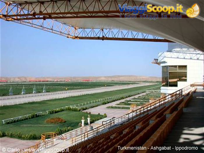 Empty grandstand at Ashgabat hippodrome, white canopy, steel trusses, green track