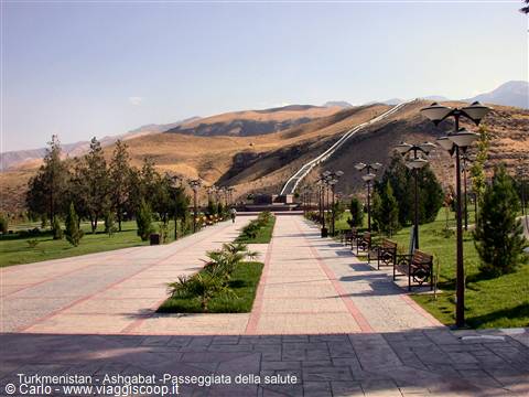 Paved walkway with benches and lampposts in Ashgabat, funicular climbs the arid hill