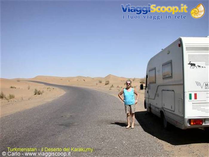 Woman beside a motorhome on the paved road through the Karakum desert, Turkmenistan