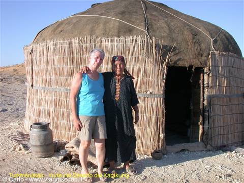 Two women in front of a reed yurt in the desert, harsh sunlight