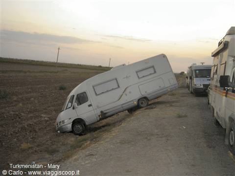 Tilted motorhome in a field near Mary, other campers on the dirt road