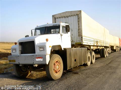 White cargo truck with covered trailer on dirt road at Turkmen-Iranian border
