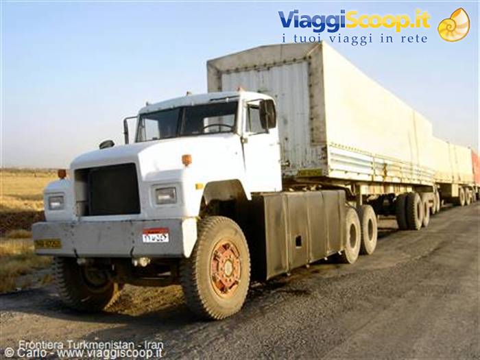 White cargo truck with covered trailer on dirt road at Turkmen-Iranian border