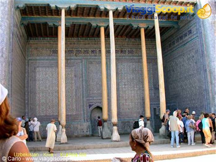 Tourists under the wooden columned portico of Khiva mosque