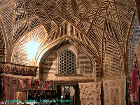 Brick vaulted ceiling of Kukeldash madrasa in Bukhara, carpets hanging below