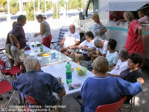Camper group lunch at folding tables beside their motorhome, Semurg Hotel, Bukhara