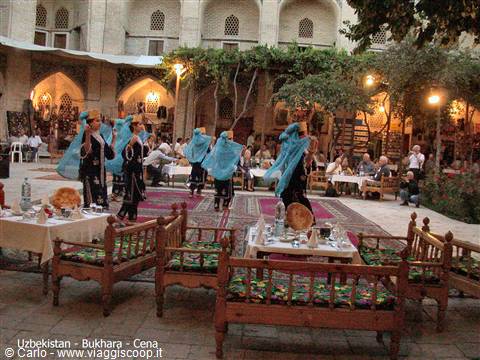 Bukhara, dancers in the Nadir Divanbegi courtyard among carpets and tea tables