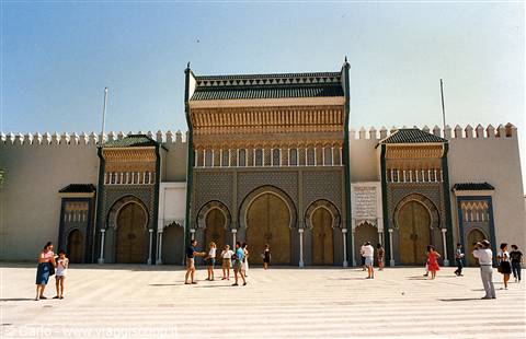 Ornate gate of Fez royal palace, tiled mosaics and painted wood under sun