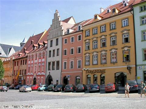 Meissen market square: colorful historic facades, parked cars and people in sunlight