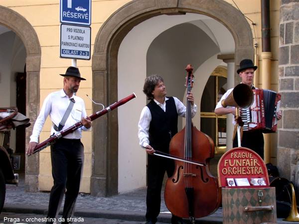 Prague street orchestra playing bassoon, double bass and accordion under stone arches