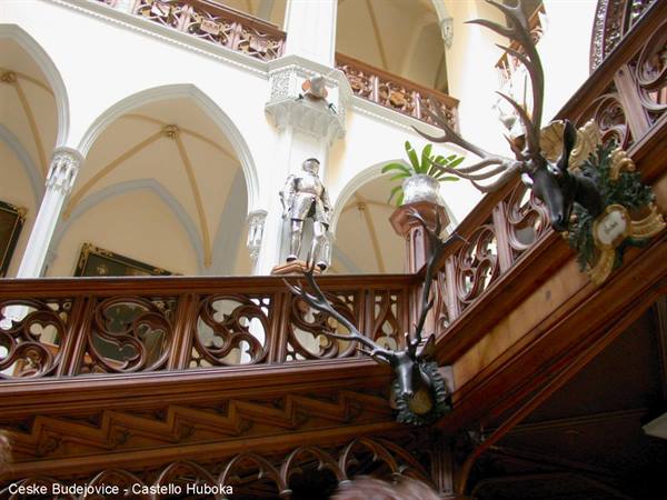 Suit of armor and deer heads inside Hluboká Castle wooden courtyard