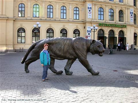 Woman posing beside the bronze tiger statue at Oslo Central Station