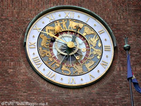Golden astronomical zodiac clock on Oslo City Hall brick wall