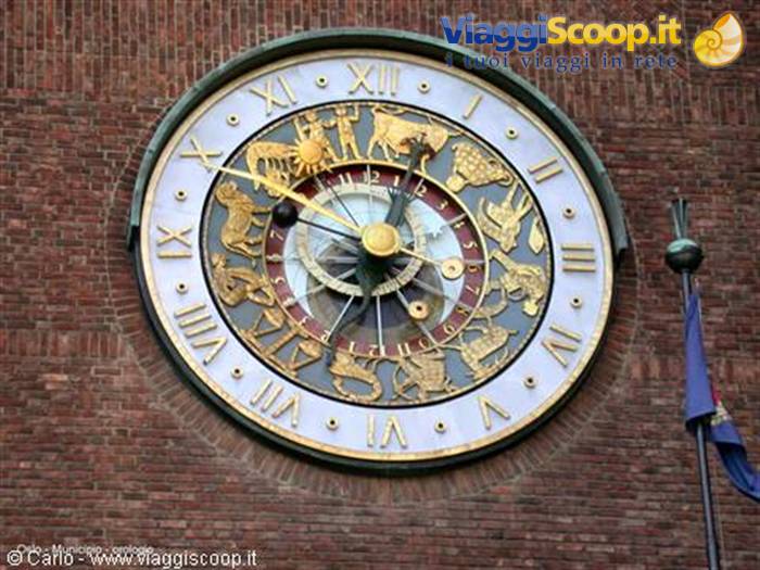 Golden astronomical zodiac clock on Oslo City Hall brick wall