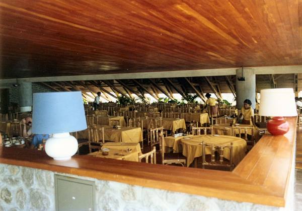 Restaurant hall with wooden ceiling, set tables and lamps on the counter