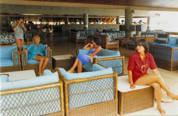 Women on blue wicker armchairs in a resort lounge hall