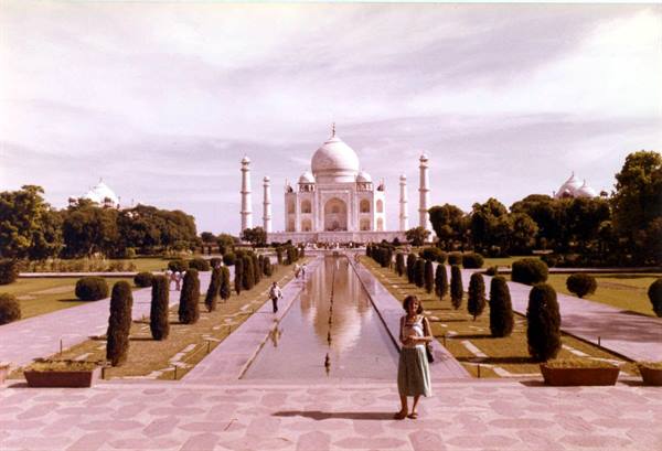 Woman standing in front of the Taj Mahal reflecting pool, Agra
