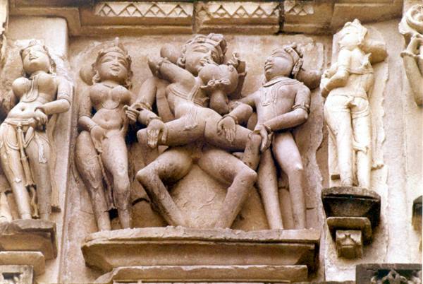 Erotic sandstone carvings on Khajuraho temples, sculpted figures in daylight
