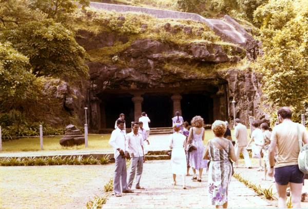 Tourists walking toward the rock-cut entrance of the Elephanta Caves