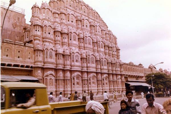 Hawa Mahal in Jaipur, pink sandstone facade, yellow truck and pedestrians