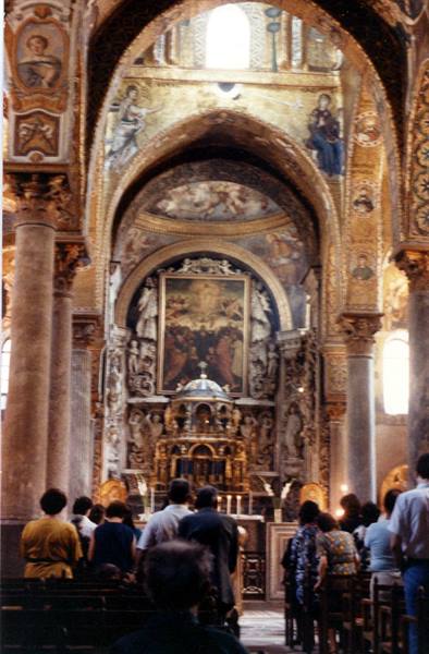 Worshippers praying before the altar in Martorana church, golden mosaics