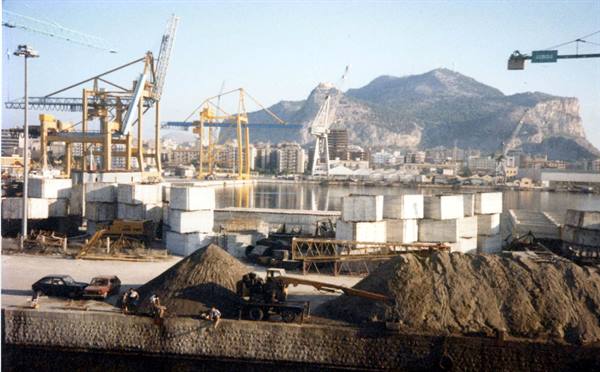 Industrial port with marble blocks, cranes and the Rock of Gibraltar
