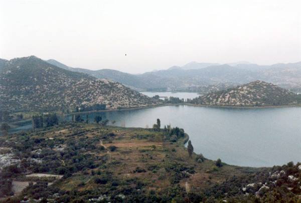 Lakes surrounded by rocky hills and Mediterranean shrubs, soft hazy light