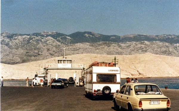 Cars and a Lepard caravan wait to board the ferry at Pag