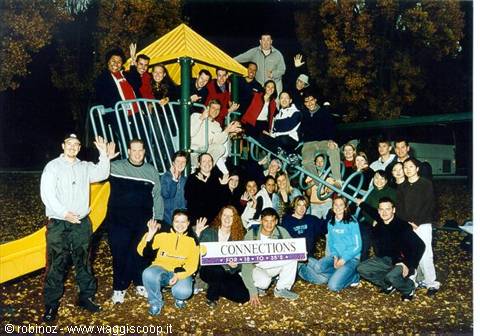 Group of young people with Connections banner on playground equipment, night flash