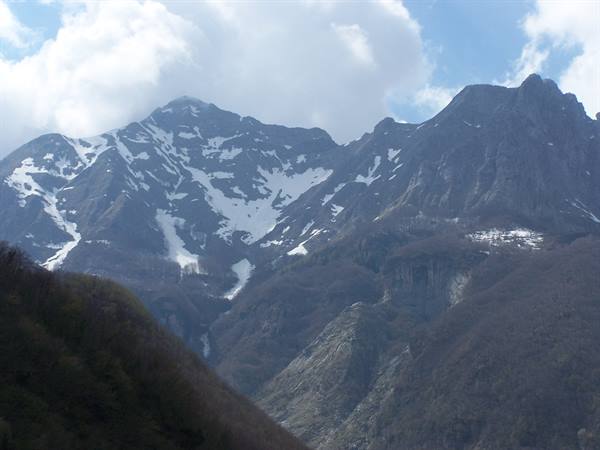 Snowy rocky peaks of the Apuan Alps, white clouds in the sky