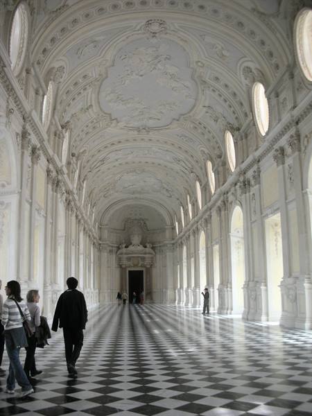 Grand Gallery of Venaria Reale, ornate white vaulted ceiling, checkered floor, visitors