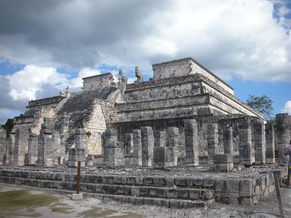 Maya stone temple with carved columns at Chichén Itzá under cloudy sky